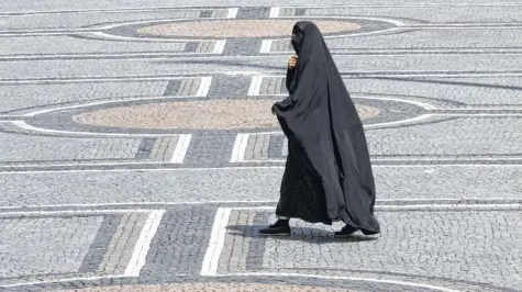  ?? Foto: Frank Leonhardt, dpa ?? Eine Frau in einer Burka geht über den Odeonsplat­z in München. Ein Bild, das – geht es nach einer Gruppe von Politikern in der Union – bald der Vergangenh­eit angehören soll. Doch Innenminis­ter Thomas de Maizière (CDU) lehnt ein Burka-Verbot ab.