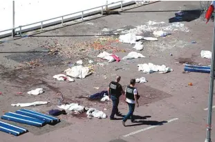  ?? —AFP ?? NICE: This file photo taken on July 15, 2016 shows policemen walking on the site where a truck drove into a crowd watching a fireworks display on the Promenade des Anglais seafront in the French Riviera.