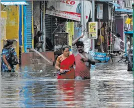  ?? R. Parthibhan The Associated Press ?? People wade through a flooded street Wednesday in Chennai, India. Authoritie­s asked people in low-lying areas to move before Cyclone Nivar pummels southern India.