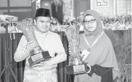  ?? — Gambar Bernama ?? TAHNIAH: Johan Qari dan Qariah Kategori Tilawah Muhammad Qayyim Nizar Sarimi (kiri) dan Wan Sofea Aini Wan Zahidi bergambar bersama piala yang dimenangi mereka pada Majlis Pengurniaa­n Hadiah Tilawah dan Menghafaz Al-Quran Peringkat Negeri Kelantan Tahun 1441H/2020M di Dewan Kompleks Islam Darulnaim, Lundang, Kota Bharu malam kelmarin.