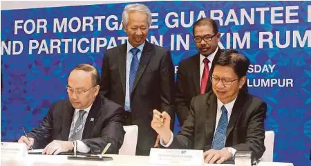  ?? PIC BY HALIM SALLEH ?? MBSB Bank Bhd president and chief executive officer (CEO) Datuk Seri Ahmad Zaini Othman (left) and Cagamas Bhd president and CEO Datuk Chung Chee Leong signing a Cagamas SRP mortgage guarantee programme agreement in Kuala Lumpur yesterday. With them...