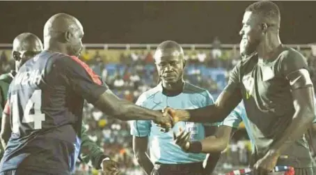  ??  ?? Super Eagles Stand in Captain, John Ogu (right), shaking President George Weah before the friendly game on Tuesday night in Monrovia