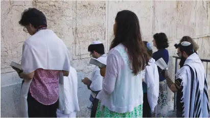  ??  ?? CONSERVATI­VE JEWS pray near Robinson’s Arch, in the section of the Western Wall prepared for egalitaria­n prayer.