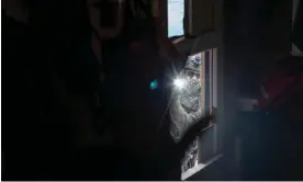  ?? Photograph: Amber Bracken ?? A militarize­d police officer looks into a tiny house after police broke the door with an axe and a chainsaw at Coyote Camp in Wet’suwet’en territory (Gidimt’en clan territory) near Houston, British Columbia, in November 2021.