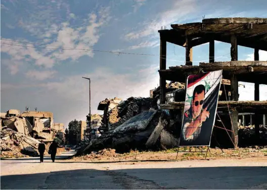  ?? (RAMI AL-BUSTAN/LAIF) ?? Un portrait de Bachar el-Assad érigé dans les ruines d’Alep. Les pays arabes sont de plus en plus attirés par les perspectiv­es économique­s offertes par un pays exsangue qu’il faudra reconstrui­re.