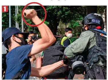  ??  ?? Clash: A protester raises his knife (circled) as police and protesters battle in Hong Kong