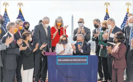  ?? Alex Brandon The Associated Press ?? House Speaker Nancy Pelosi, D-calif., and Senate Majority Leader Chuck Schumer, D-N.Y., celebrate after signing the $1.9 trillion coronaviru­s relief bill during a ceremony Wednesday on Capitol Hill in Washington.