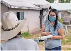  ?? JIM THOMPSON/JOURNAL ?? Catherine Lee, a community health representa­tive, talks with a man at his home on the Navajo Nation.