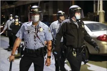  ?? AP PHOTO/MICHAEL PEREZ ?? A Philadelph­ia police o cer is covered with an unidentifi­ed red substance during a confrontat­ion with protesters, on Tuesday in Philadelph­ia.