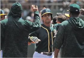  ?? Carlos Avila Gonzalez / The Chronicle ?? Khris Davis is congratula­ted by teammates during an August game after hitting a home run, a frequent occurrence in his three seasons with the A’s.