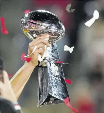  ??  ?? Tampa Bay Buccaneers quarterbac­k Tom Brady (12) holds up the Vince Lombardi Trophy on stage after the NFL Super Bowl 55 football game against the Kansas City Chiefs.