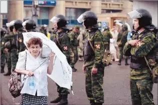  ?? Alexander Zemlianich­enko Associated Press ?? Despite rain in Moscow, this woman joined the protest against Vladimir Putin in front of a strong police presence.
The protesters
were not deterred by
Putin’s tough new measures against dissent.