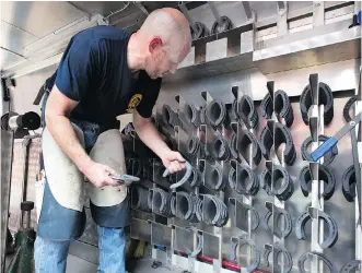  ??  ?? Farrier Thomas Nolan chooses from the assortment of shoes in the NYPD’s mobile workshop. The NYPD has two such mobile horseshoe units stocked with all manner of anvils, hammers, nippers and pullers.