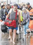  ?? Melissa Phillip / Houston Chronicle ?? Storm evacuees walk along Interstate 45 S. near Edgebrook before being shuttle to a shelter on Sunday.