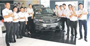  ??  ?? Tan Kim Hoon (fifth left), Kenn Tan (sixth right) and sales advisors pose with the newly-launched Proton X70.