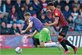  ?? Picture: Daniel Murphy ?? Bristol City’s Chris Martin tumbles under a challenge from Bournemout­h’s former Robins defender Lloyd Kelly