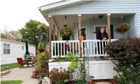  ?? Photograph: Sara Terry/Mobile Movies ?? Candi Evans leans over the balcony of her home in Golfview mobile home park in Iowa.