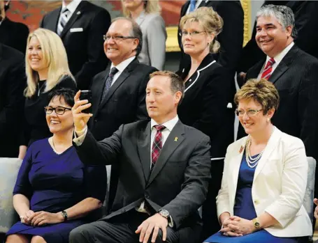  ?? SEAN KILPATRICK/CANADIAN PRESS ?? Minister of Justice and Attorney General of Canada Peter MacKay settles into his new role Monday alongside Minister of Environmen­t Leona Aglukkaq, left, and Minister of Public Works and Government Services Diane Finley for a group photo following a...
