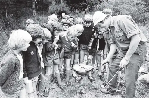 ?? PHOTO: OTAGO DAILY TIMES FILES ?? Dave Hammond, a Tainui cub leader, is surrounded by cubs as he cooks sausages at the Founders Day ceremony at Waiora in March 1979. More than 650 boys from as far away as Oamaru and Balclutha took part in the national cub day.