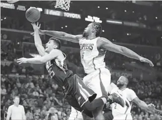  ?? Danny Moloshok Associated Press ?? CLIPPERS CENTER DeAndre Jordan, right, fouls Utah guard Raul Neto in the first half.