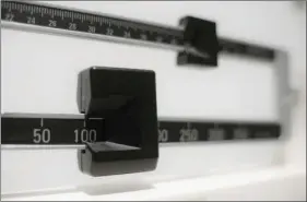  ?? AP PHOTO/PATRICK SISON ?? This Tuesday photo shows a closeup of a beam scale in New York. New research released on Wednesday suggests there’s a critical window for overweight kids to get to a healthy level.