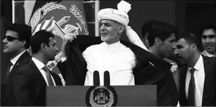  ?? AP PHOTO/RAHMAT GUL ?? Afghan President Ashraf Ghani (center) opens his coat after a few rockets are fired during his speech after being sworn, at his inaugurati­on ceremony at the presidenti­al palace in Kabul, Afghanista­n, on Monday.