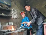  ??  ?? Wu Shuigen instructs his daughter in making silver jewelry in Shidong town, Guizhou province.