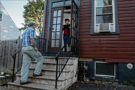  ?? Photos by Lori Van Buren / Times Union ?? Tim Doherty checks in with a refugee family he rents a house to down the street from his West Hill Refugee Welcome Center on Tuesday in Albany.
