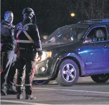  ?? GAVIN YOUNG/ CALGARY HERALD ?? Police look over a damaged Ford Explorer following an officer- involved shooting on Riverfront Avenue on Tuesday afternoon. Police are scheduled to release more details.