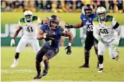  ?? [AP PHOTO] ?? Tulsa’s D’Angelo Brewer (4) carries the ball past South Florida’s Greg Reaves (41) and Bruce Hector (60) on Nov. 16 in Tampa, Fla. STILLWATER —