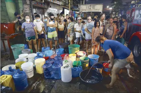  ?? MIGUEL DE GUZMAN ?? Residents ignore physical distancing as they line up for water in Tondo, Manila on Sunday. Water service interrupti­ons hit parts of Manila over the weekend.