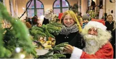  ?? RP-FOTO: STEPHAN KÖHLEN ?? Joyce (8) und der Weihnachts­mann schmücken den Tannenbaum im Eisenbahnm­useum.