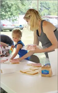  ?? MEGAN DAVIS/MCDONALD COUNTY PRESS ?? Attendees enjoyed a picnic lunch provided by sponsors and prepared by Rosie Roberts, 3, and Alyssa Clark.