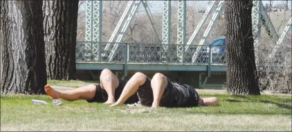  ?? NEWS PHOTO COLLIN GALLANT ?? Hatters soak up the sun at Riverside Veterans Memorial Park in downtown on Friday afternoon. Temperatur­es are expected to reach summerlike highs on Saturday following a long, cool early spring.