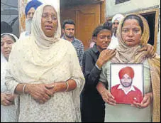  ?? HT PHOTO ?? Aggrieved family members with the picture of victim sarpanch Gurpinder Singh at Chet Singh Wala village in Amritsar district on Wednesday.