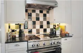  ??  ?? Checkerboa­rd tiles behind the stove brighten the cooking space.