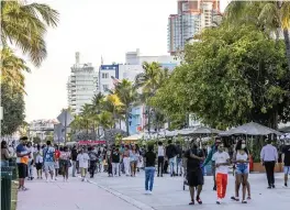  ?? DANIEL A. VARELA dvarela@miamiheral­d.com ?? People stroll on Ocean Drive before curfew in Miami Beach on Tuesday.