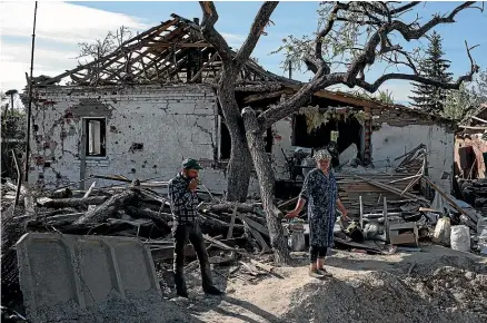  ?? GETTY IMAGES ?? Ukrainian couple Larysa, 55, and Viktor, 57, look at the remains of their home in the village of Pidhaine, near the capital, Kyiv. As Russia concentrat­es its attack on the east and south of the country, residents of the Kyiv region are returning to assess the war’s toll on their communitie­s.