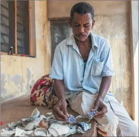  ?? XIE SONGXIN / CHINA DAILY ?? Mansur Ile, a resident of Siyu in Pate Island, Kenya, sorts out porcelain fragments he has collected on the shore near the village.