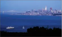  ?? AP PHOTO BY ERIC RISBERG ?? In this photo taken Saturday, July 22, the setting sun is reflected on the Salesforce Tower in the San Francisco skyline in this view from Sausalito.