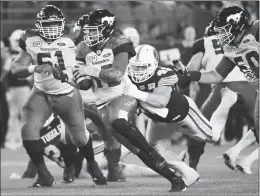  ?? Canadian Press photo ?? Calgary Stampeders quarterbac­k Bo Levi Mitchell (19) is chased by Toronto Argonauts defensive lineman Jeffrey Finley (49) during second half CFL football action in Toronto on Thursday.