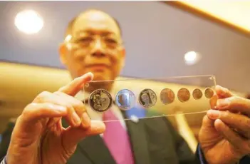  ?? (Jonathan Cellona, ABS-CBN News/File photo) ?? Bangko Sentral ng Pilipinas Governor Benjamin Diokno holds newly minted set of 20-piso and Enhanced 5-piso NGC coins at the Executive Business Center at the Bangko Sentral ng Pilipinas, (BSP) in Manila on December 17, 2019.