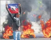  ?? AP ?? A demonstrat­or holds up a Haitian flag during protests in Port-au-Prince, Haiti, on March 1.