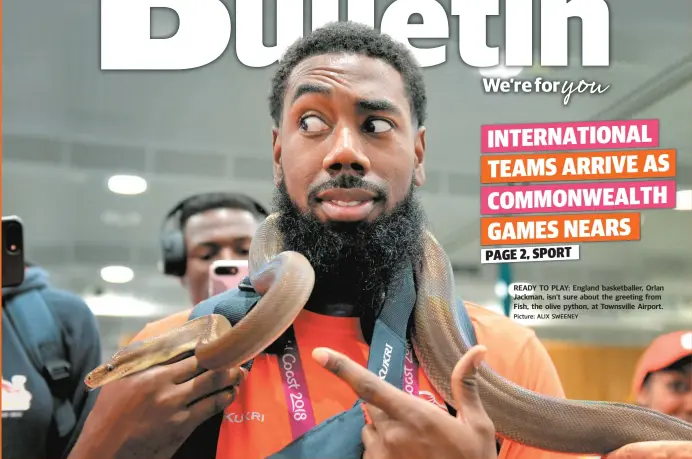  ?? Picture: ALIX SWEENEY ?? READY TO PLAY: England basketball­er, Orlan Jackman, isn’t sure about the greeting from Fish, the olive python, at Townsville Airport.