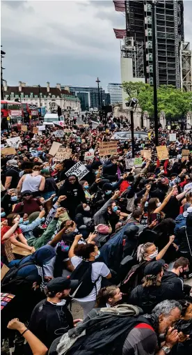  ??  ?? March on Westminste­r: As many as 2,000 protesters – many of whom brought placards reading Black Lives Matter, or BLM – raise their fists in solidarity with US demonstrat­ors in the shadow of the Houses of Parliament