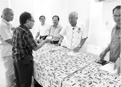  ??  ?? Manyin presents a cheque to a recipient. On his right is Dr Sinang