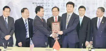  ??  ?? Abang Johari (centre) witnessing the exchange of MoU between Pahon and Liu. Also seen (from right) are Mohamad Morshidi, Fu, Wong and Lee. — Photo by Chimon Upon