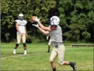  ?? DIGITAL FIRST MEDIA FILE ?? A Perkiomen School receiver hauls in a pass from quarterbac­k Nick Guadarrama during the team’s practice last summer.