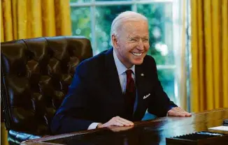  ?? Kevin Lamarque/Reuters ?? Joe Biden sorri a jornalista­s após assinar ordem executiva no Salão Oval