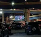  ?? COURTESY ANNE KOLLER ?? People stay in their cars while watching "The Goonies" at the first Parking Lot Theatre event, held in a lot on St. Paul Avenue in the Menomonee Valley.